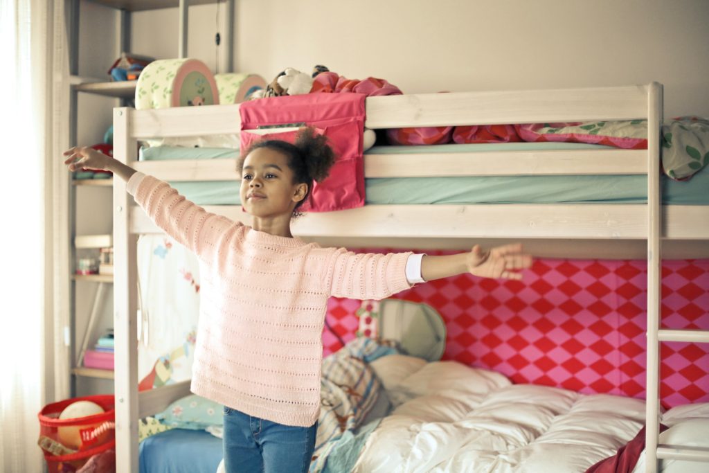 Young girl stood in front of bunk bed